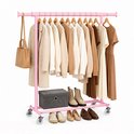Roze kledingrek volgehangen met beige kleding, handtassen, opbergdoos en diverse schoenen.