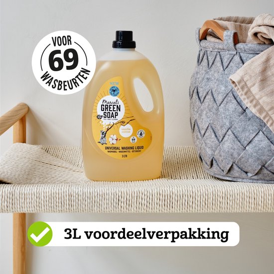 Gele vloeistof in een witte fles, 'voor 69 wasbeurten'. Staat op een bankje met mand met wasgoed.