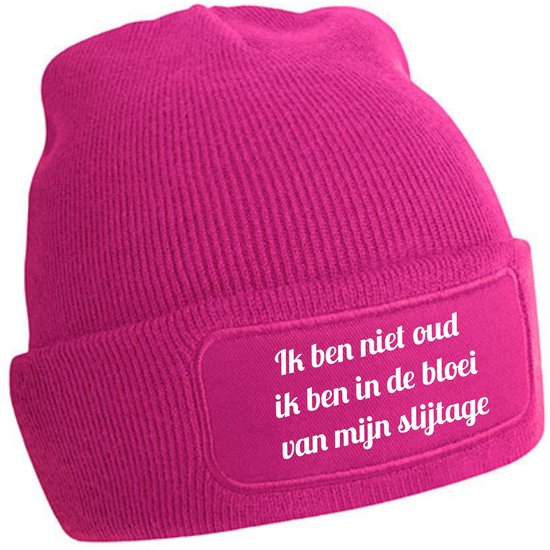 Fuchsia roze gebreide muts met tekst: 'Ik ben niet oud, ik ben in de bloei van mijn slijtage'.
