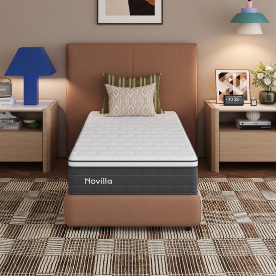 Novilla matras in een slaapkamer met een bruine bedombouw en beige gestreept tapijt.