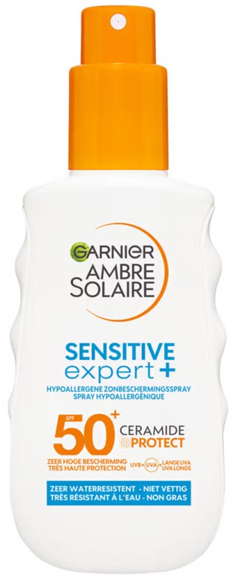 Witte fles Garnier Ambre Solaire zonnebrandspray SPF50+ met oranje dop en bescherming voor de gevoelige huid.