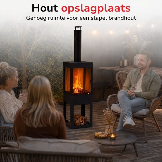 Zwarte buitenhaard met schoorsteen, brandend vuur en ruimte voor houtopslag. Mensen op terras.