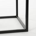 Dichtbij zicht op het zwarte metalen frame van een bijzettafel.