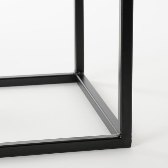 Dichtbij zicht op het zwarte metalen frame van een bijzettafel.