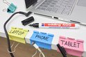 Kabelclips met labels "Laptop", "Phone" en "Tablet", bij een laptop, met een Edding 400 stift.