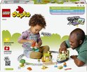 Kind bouwt met LEGO DUPLO treinset op een doos terwijl een volwassene toekijkt. Tekst: 'Fine motor skills'.