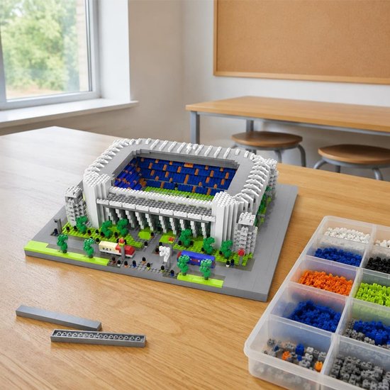 Bernabéu stadion bouwset op een houten tafel, naast een sorteerbak met gekleurde bouwblokjes.