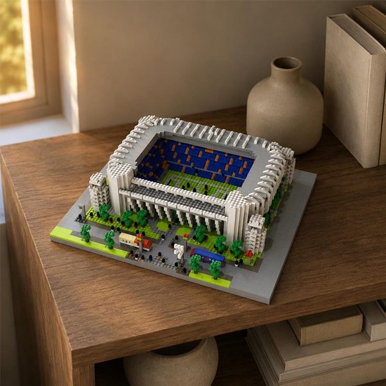 Bernabéu stadion bouwmodel geplaatst op een houten bureau naast boeken en een keramische vaas.