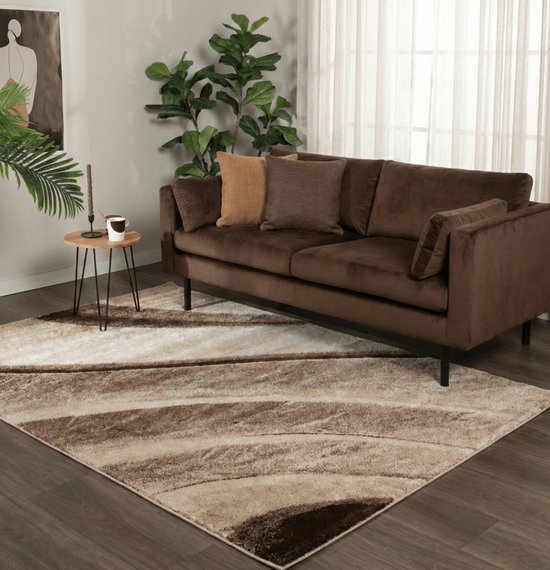 Modern, rechthoekig vloerkleed met abstracte golvende lijnen in bruin- en beigetinten voor een woonkamer.