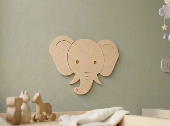 Close-up van een minimalistische houten olifant muurdecoratie boven een commode.