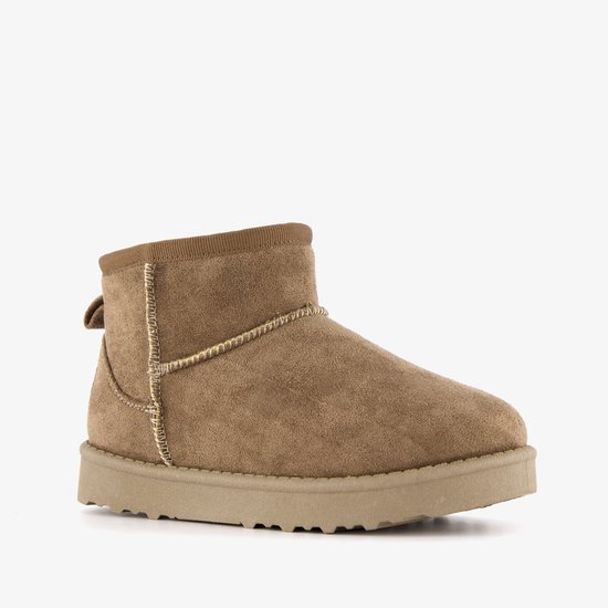 Beige suède enkellaars met bruine bontvoering, decoratieve stiksels en label op de hak.