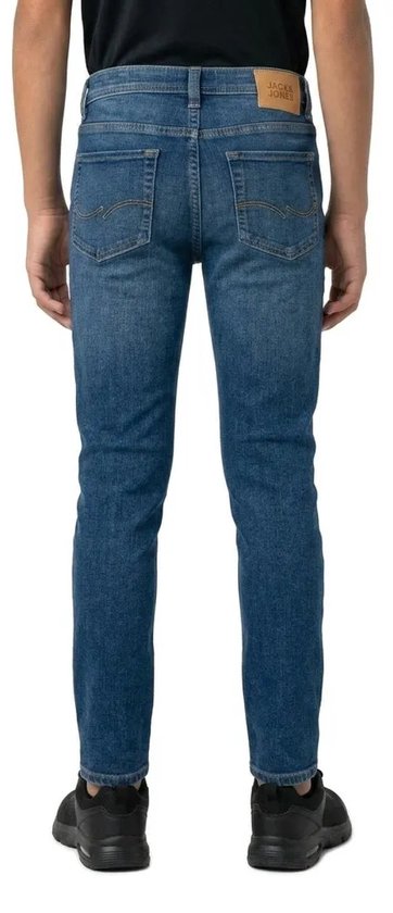 Jongens jeans in een donkerblauwe denim wassing, met een slim fit pasvorm. Gedragen op zwarte sneakers.
