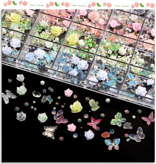 Een doos met 24 vakjes gevuld met diverse nail art decoraties: rozen, vlinders, parels en strass steentjes in pastelkleuren en blauw.