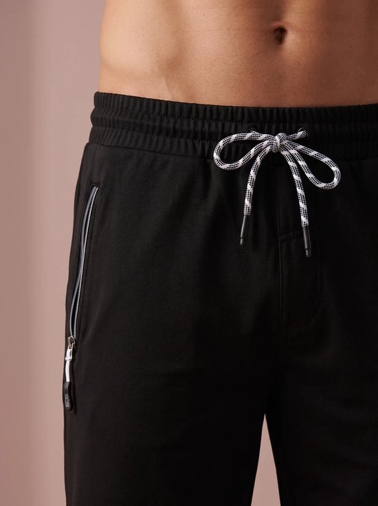 Close-up van een zwarte short met elastische tailleband en tweekleurig trekkoord.