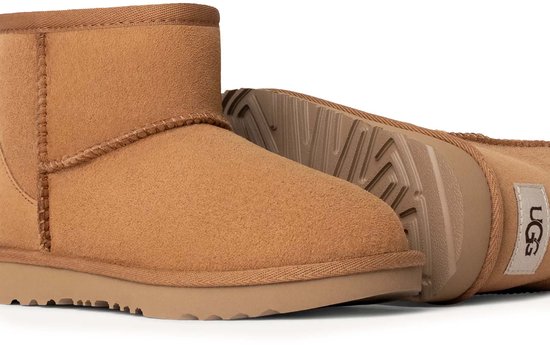 Twee bruine UGG Classic Mini II kinderlaarzen, één met zool zichtbaar, op een witte achtergrond.