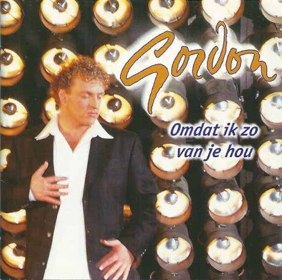 Gordon in een zwart colbert en wit hemd voor een achtergrond van felverlichte theaterspots met de tekst: Omdat ik zo van je hou.