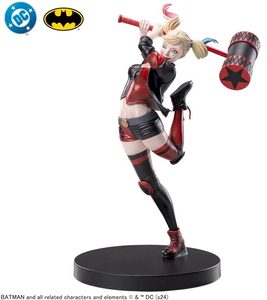 Harley Quinn actiefiguur met hamer, staartjes en rode en zwarte outfit op een zwarte sokkel.