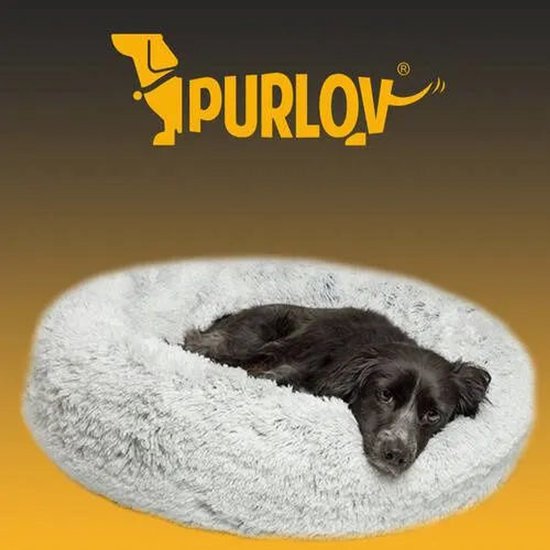 Zwarte hond rust in een ronde, pluizige grijze Purlov-mand.