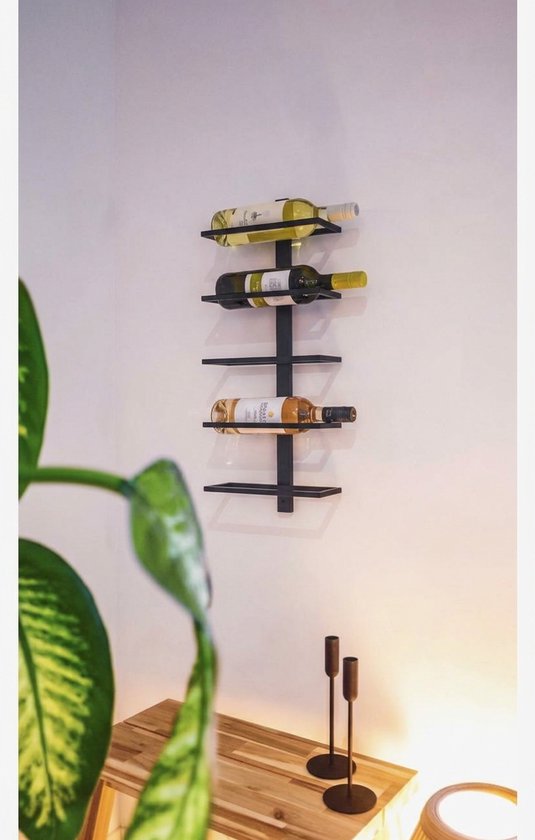 Modern matzwart wandwijnrek met drie flessen, gemonteerd aan een witte muur boven een houten tafel.