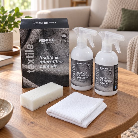 Fenice textiel- en microvezelverzorgingsset met twee sprays, spons en doek op een houten tafel in een woonkamer.