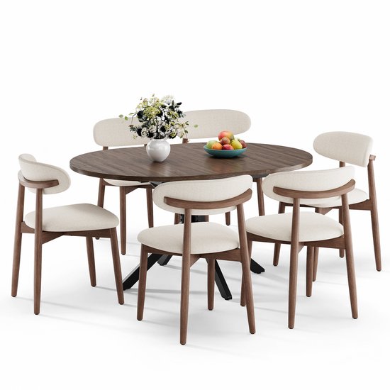 Table à manger ronde couleur noyer avec pieds en métal noir et quatre chaises beiges, incluant un bol de fruits.