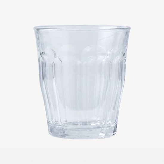 Un verre à eau Duralex Picardie en verre trempé transparent, avec côtes verticales. Isolé sur un fond clair.