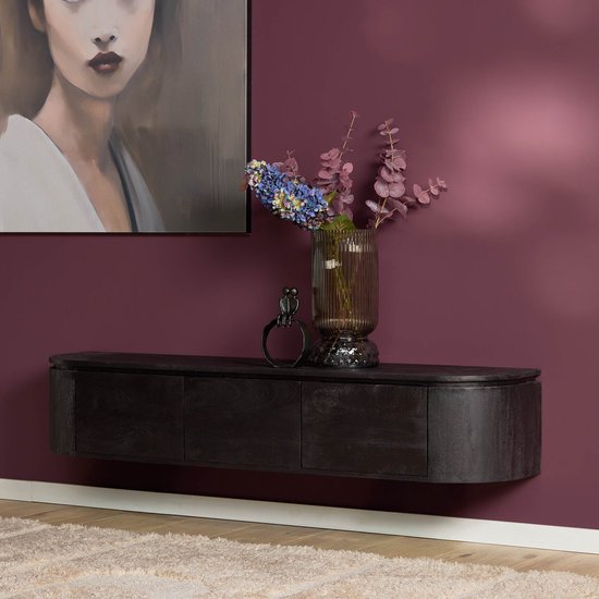 Zwart houten wandmeubel tegen een donkerrode muur, aangekleed met een vaas met bloemen en een decoratief beeldje.