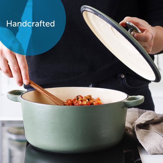 Groene braadpan met deksel, handmatig op een kookplaat geplaatst.