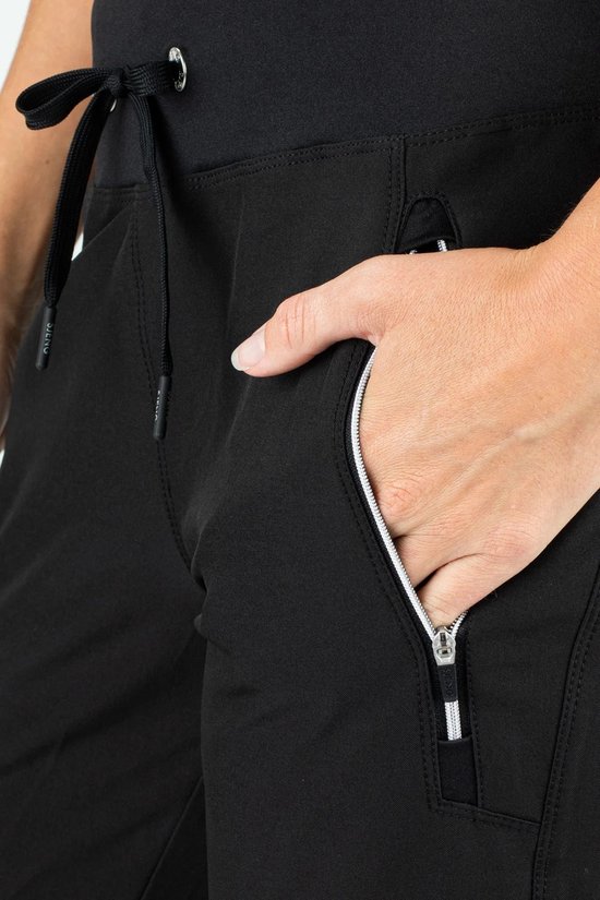 Dames trainingsbroek zwart met een ritssluiting aan de zijkant en een zilverkleurig detail op de rits.