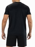 Achterkant van een man in een zwart sportshirt met fijne horizontale strepen en zwarte sportshorts.