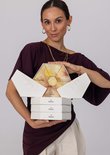 Vrouw met Purelei adventskalender. De open bovenkant toont een hexagonaal ontwerp met bloemenprints en de tekst 'Love your glow'.