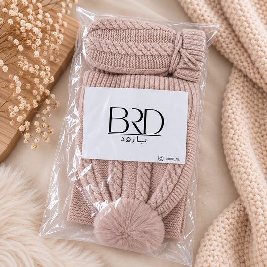 Beige gebreide kinderset met kabelpatroon in verpakking. Muts met pompon en wanten.