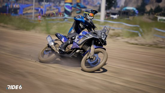 Motorrijder in blauw-zwart pak op een blauwe motor in het stof.