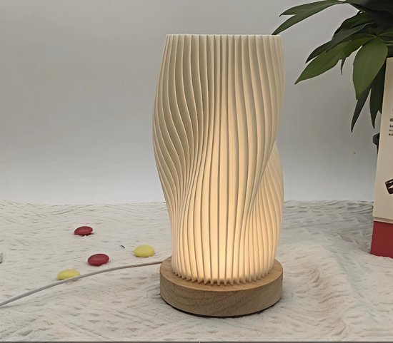 Gebogen tafellamp met geribbelde textuur en houten voet op een wit tafelkleed.