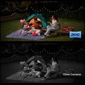 Familie kampeert buiten in het donker, met verlichting van een tent en lichtsnoeren. "2K HD" logo.