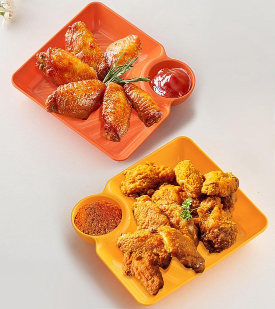 Twee vierkante serveerschalen, een oranje met kippenvleugels en ketchup, een gele met gefrituurde kip en kruiden.