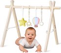 Baby ligt onder houten babygym met gele ster, houten olifant, ballon en ring. Baby draagt een wit rompertje.