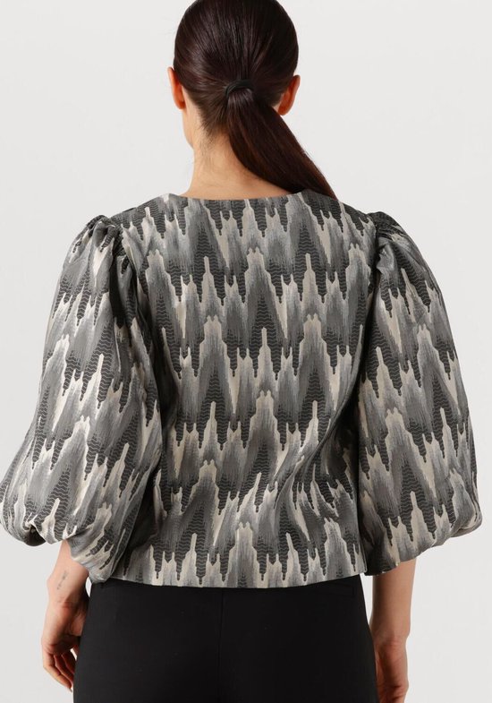 Achterkant blouse met volumineuze mouwen en een zigzag patroon in grijs, wit en zwart.