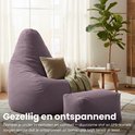 Gezellige mauve zitzak en voetenbankje in een woonkamer, met plaid en kussen op de zitzak.