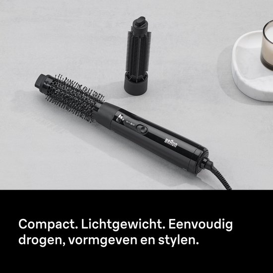 Zwarte stijltangborstel op een grijze achtergrond, met één opzetstuk. Compact, lichtgewicht, drogen, vormen en stylen.
