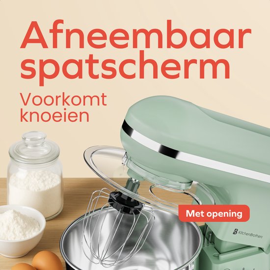 Pastelgroene keukenmachine met spatscherm met opening. Naast bloem en eieren.