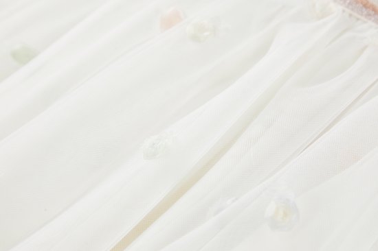 Veelkleurige stippen op een off-white tule rok, dichtbij.