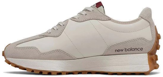 Off-white sneaker met beige suède overlays en de tekst 'new balance' op de zijkant. Rubberen zool.