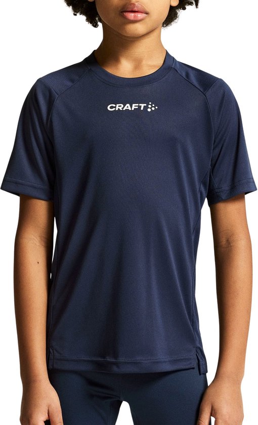 Jongen in donkerblauw Craft sportshirt met korte mouwen en wit Craft logo op de borst.