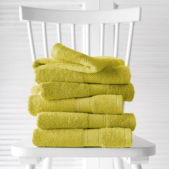 Pile de torchons vert olive chaud avec nervures, sur une chaise blanche.