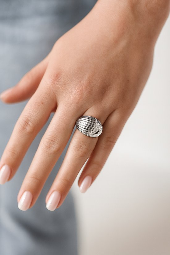 Bague Lundholm argentée à texture côtelée, portée au doigt d'une femme.