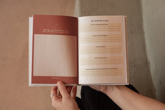 Open boek met perzikroze kaft. Linkerpagina bevat een foto-invoegruimte en tekst. Rechterpagina bevat invulvragen.