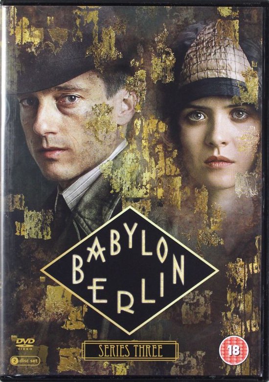 DVD hoes van Babylon Berlin Serie Drie. Twee personen, een man met hoed en gestreken overhemd, en een vrouw met hoed. Gouden patronen op de achtergrond.