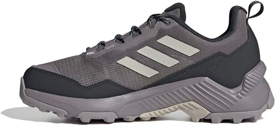 Grijze Adidas Terrex wandelschoen, zijkant met lichte strepen en zwarte hiel.