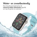 Apple Watch met lichtblauw bandje in water, wat de waterbestendigheid aangeeft.